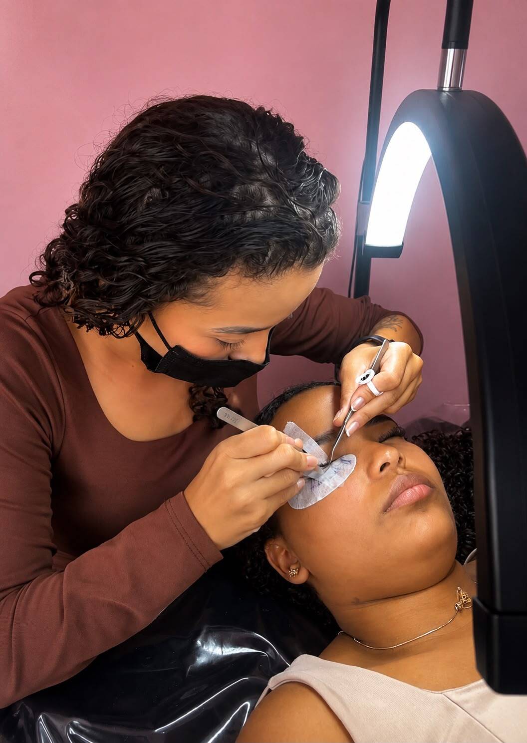 Aluna praticando extensão de cílios em modelo real